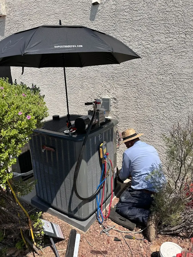 HVAC technician performing outdoor AC maintenance in Snowflake