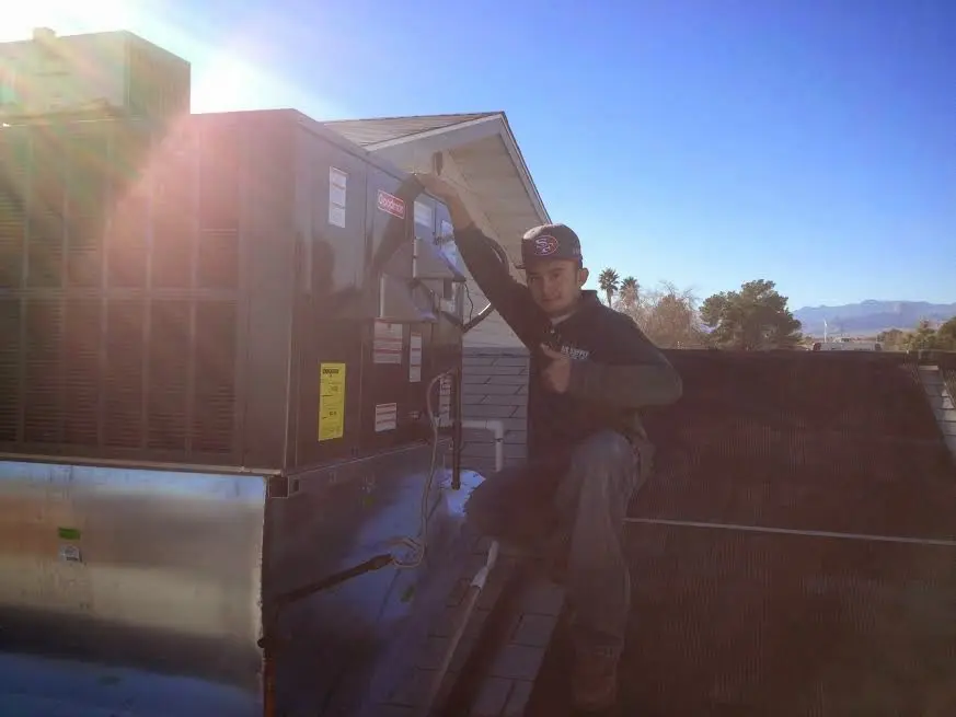 HVAC technician performing Heat Pump Repair on a rooftop unit in Snowflake